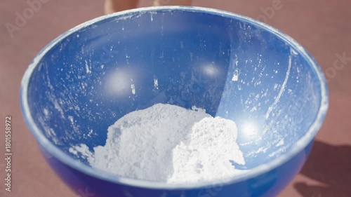 The hands of a professional athlete are dipped in the putra powder. Shot in slow motion