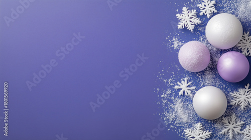 A blue background with white snowflakes and white and purple balls