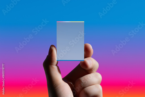 Hand holding mirror against vivid gradient background