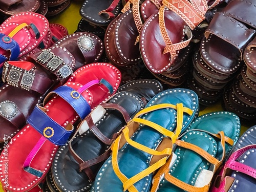 Colorful Handmade chappals (sandals) being sold in an Indian market, Handmade leather slippers, Traditional footwear.