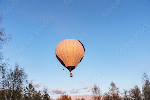White with black hot air balloon in the sky. Beautiful balloon against a blue sky.
