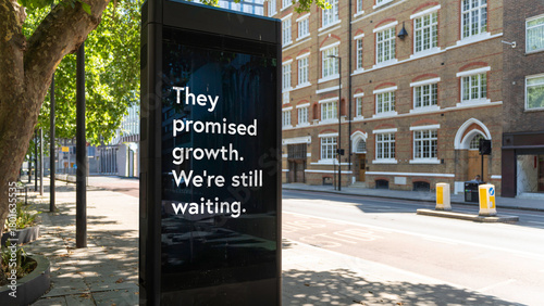 Street billboard with message reading They promised growth we’re still waiting