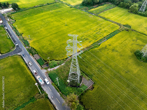 Sunset behind electricity pylons and green field.