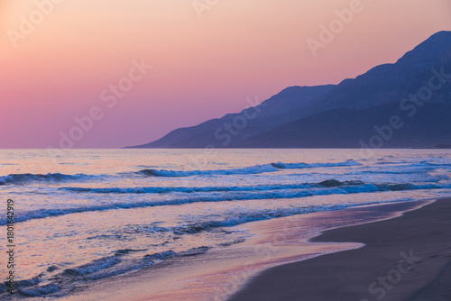Fototapeta Naklejka Na Ścianę i Meble -  Tranquil seaside scene featuring gentle waves, a sandy shoreline