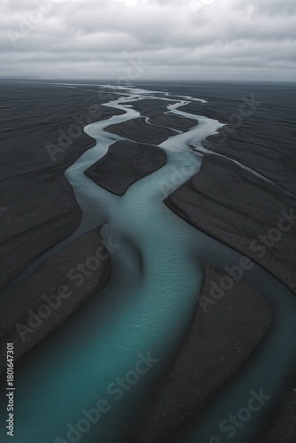 Aerial turquoise river channels over dark sand