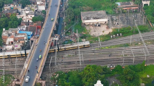4k Top Down Aerial View of Train Passing Under Road Bridge Traffic near Green Lake in City.