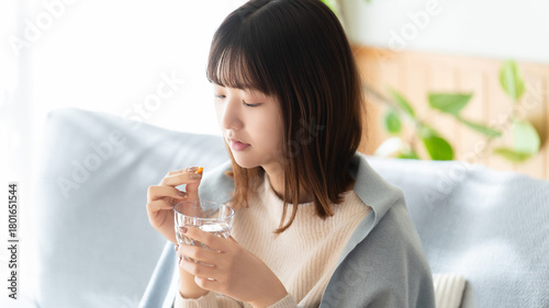 Foto 薬を飲む体調不良の女性