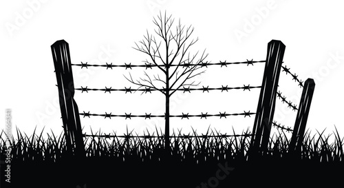 Dramatic barren tree behind barbed wire fence in silhouette style