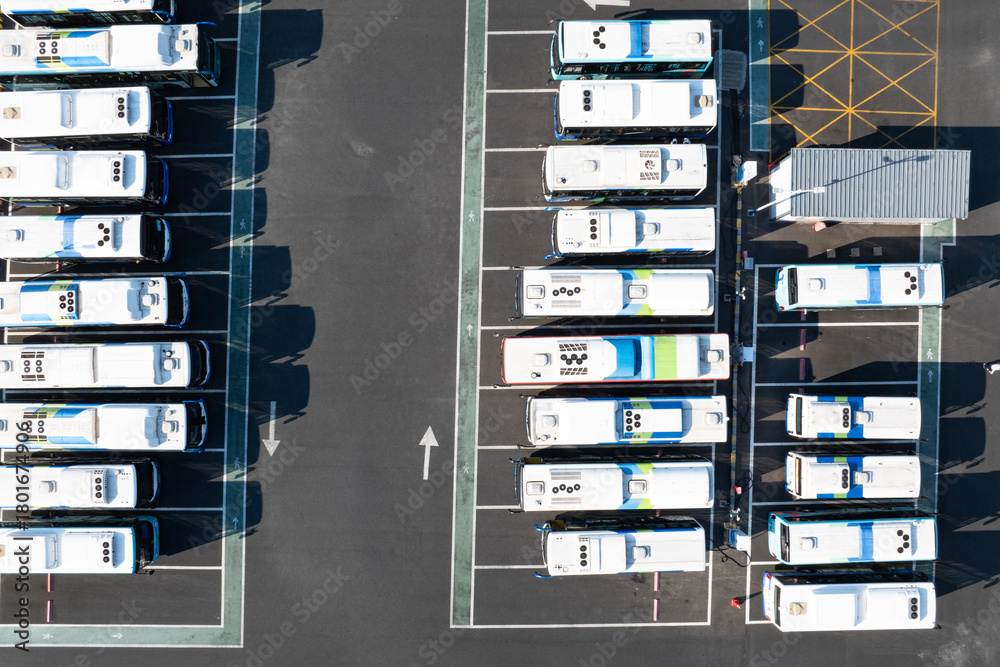 Naklejka premium Aerial view of electric buses parked in an orderly parking lot
