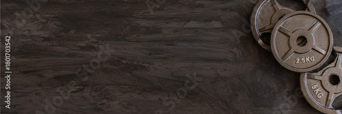 Heavy iron weightlifting plates in 2.5kg, 5kg, and 10kg sizes lined up,  gym ифттук, strength training visuals, personal training advertising, and workout inspiration.