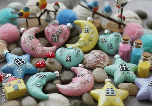 Still life with miniature ornaments of stars moons hearts and houses interspersed with pebbles and miniature bottles