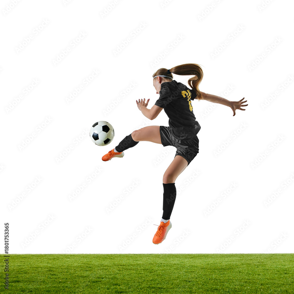 Naklejka premium Female football player in powerful mid-air strike with focused intensity. Concept of peak action, sports ads, agility programs, fitness promotion, match visuals.