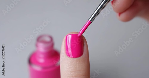 Applying pink nail polish