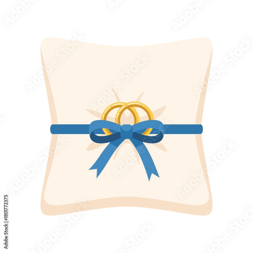 A pillow holds two golden rings secured by a blue ribbon and bow.
