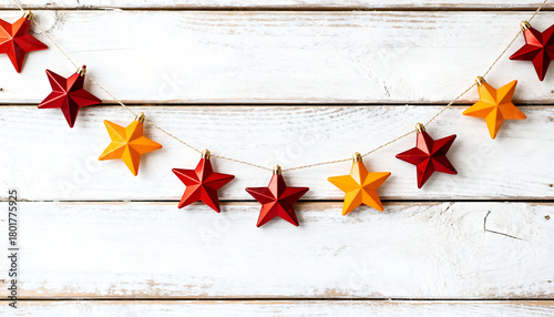 Christmas star garland hanging on rustic wooden wall. Warm festive decoration.