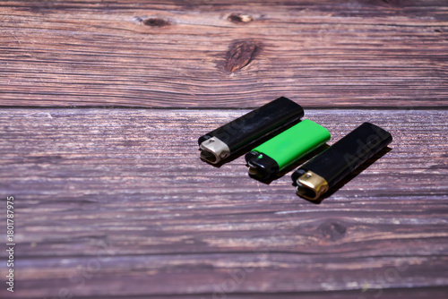 Lighter on a wooden background. Top view. Lighters on a table. Fire for cigarette.