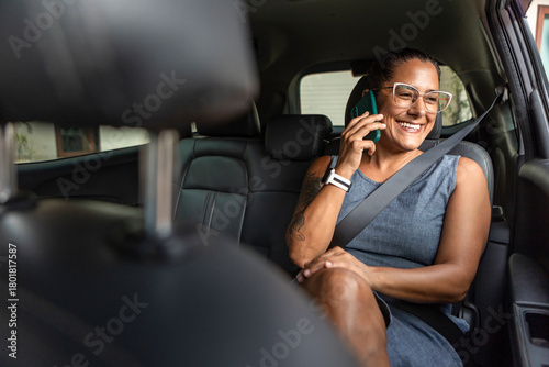 Businesswoman talking on phone in car interior
