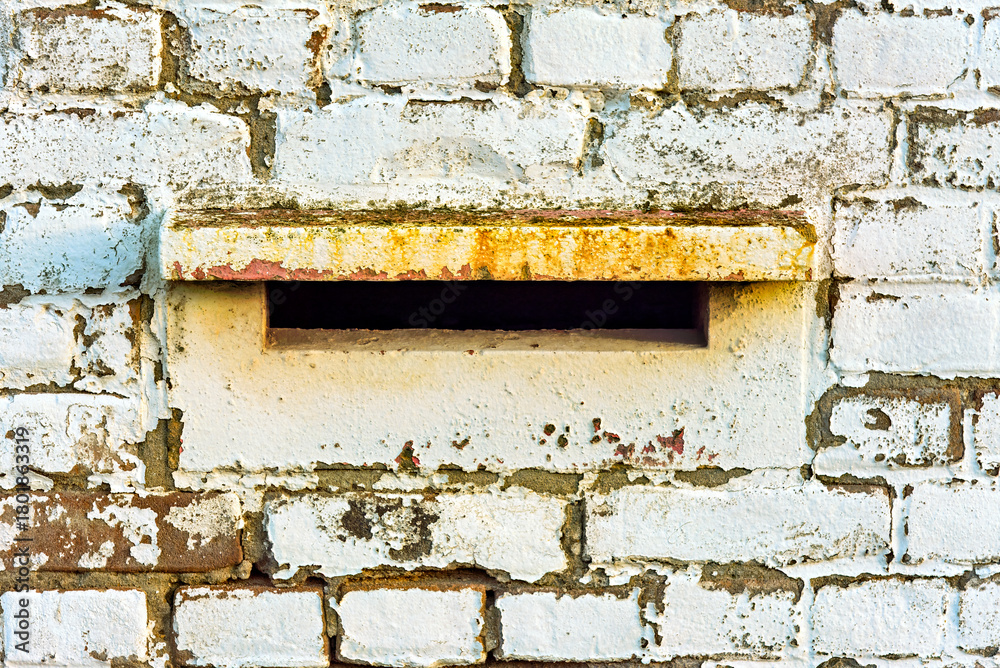 Naklejka premium white-leaved stone wall with a letterbox built into the wall