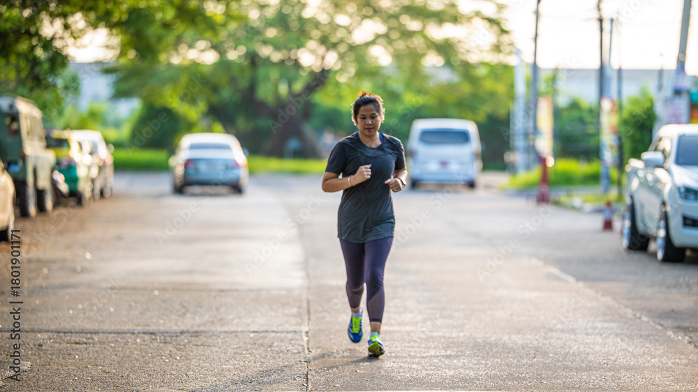 Obraz premium Beautiful asian sport active woman sprint run on city road morning sun light