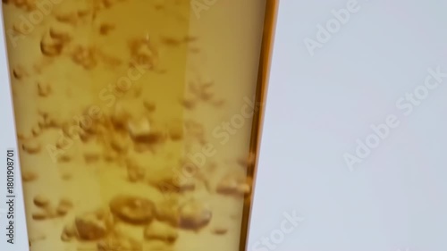 Close up of a beer glass with bubbles and foam, refreshing drink.
