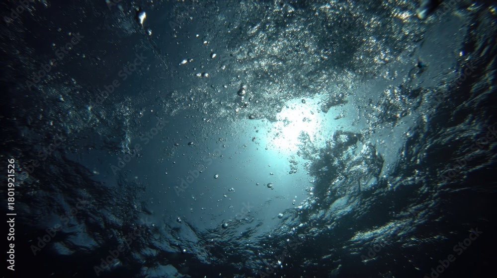 Fototapeta premium Underwater Perspective Looking Up Toward the Surface with Sunlight and Bubbles