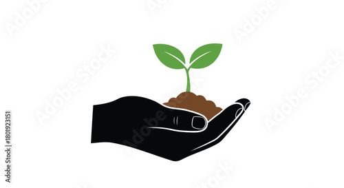 Black silhouette of a hand gently holding a small green seedling growing in rich brown soil