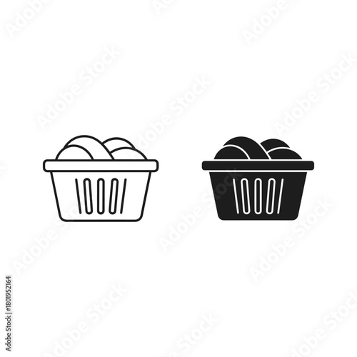 Laundry basket with clothes, one black and one white isolated on