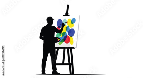Silhouette of an artist painting a colorful abstract artwork on a canvas on an easel
