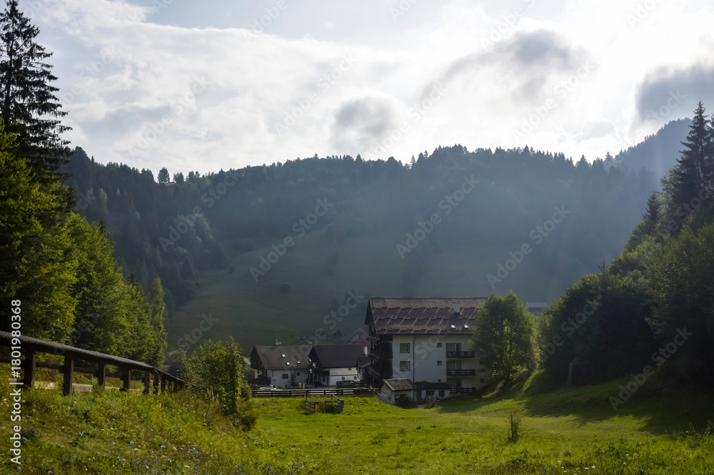 Naklejka premium Picturesque view of cozy hotel complex in mountains of Romanian Carpathians in early morning. Copy space.