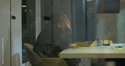 Fotografi African American businesswoman sits in silence at office table with hand over fa