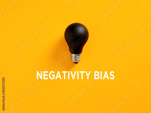 Canvas Print Negativity bias represented by a black light bulb on yellow background