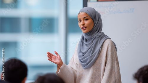 Young Muslim woman teaching in classroom while engaging with students  
