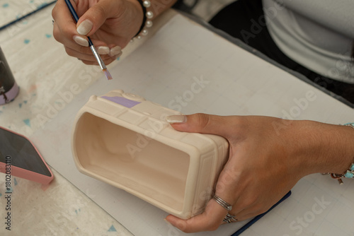 Detalle de manos pintando artesanías