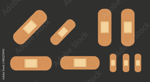 Collection various sizes adhesive bandages, also known as bandaids, displayed against dark, illustrating first aid and wound care supplies