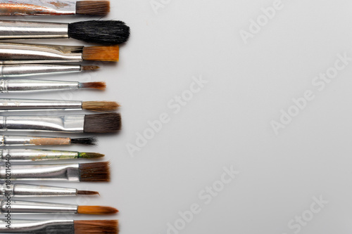 Many different brushes on a white background. Copy space for artistic background.