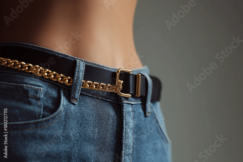 Luxury fashion close-up of woman's jeans waistline with designer belt detail