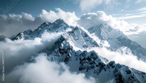 A breathtaking aerial view of jagged, snow-covered mountain summits piercing through a sea of white clouds.