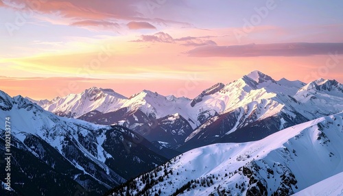 A breathtaking panoramic view of snow-covered mountains under a soft, colorful sunrise sky, showcasing rugged peaks and deep valleys.