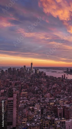 Vertical time-lapse video of New York City skyline showing a vivid sunset and transition from day to night over the Hudson River