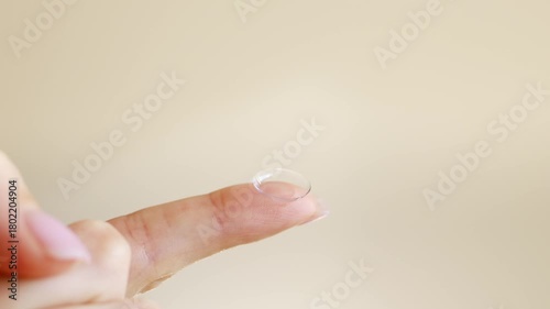 Close-up of a hand holding a soft contact lens on fingertip. Vision correction, eye care, and ophthalmology concept with daily disposable lens.