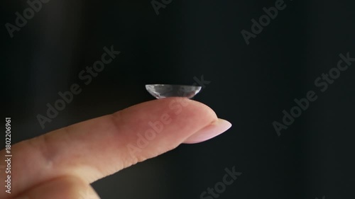Close-up of a hand holding a soft contact lens on fingertip. Vision correction, eye care, and ophthalmology concept with daily disposable lens.