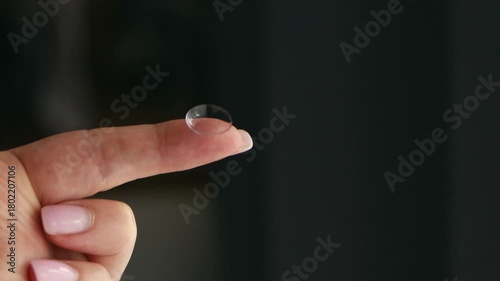 Close-up of a hand holding a soft contact lens on fingertip. Vision correction, eye care, and ophthalmology concept with daily disposable lens.
