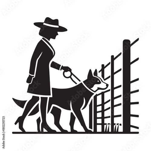 Woman walking dog near fence focused on training.