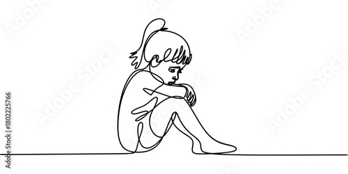 a sad child sitting with knees up, expressing loneliness and quiet emotion.