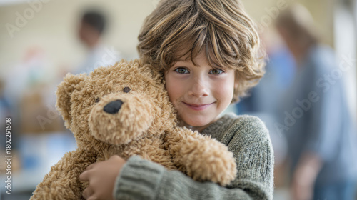 Happy caucasian boy hugging cute brown teddy bear. stuffed animal gift provides comfort and joy to smiling child with content look