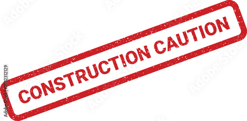 A distressed red rubber stamp impression showing the words Construction Caution is placed diagonally on a clean white surface