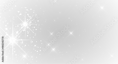 Fine silver dust floats through the air with a soft shimmering glow. Small highlights appear around the drifting sparkles. The gentle shine creates a calm festive mood.