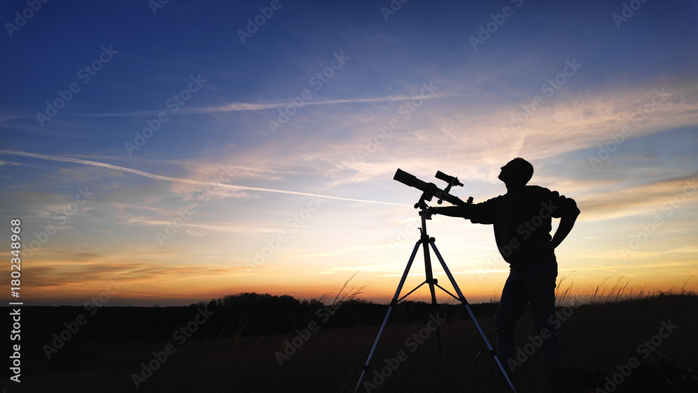 Fototapeta premium Silhouette of an amateur astronomer using telescope for observing stars, planets, Moon and other celestial objects.