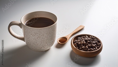 minimalist coffee still life featuring a speckled ceramic mug wooden spoon and bowl of roasted coffee beans on a clean white surface concept of morning routine caffeine and simple pleasures