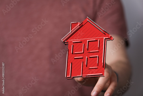 A hand presenting a red hou...
